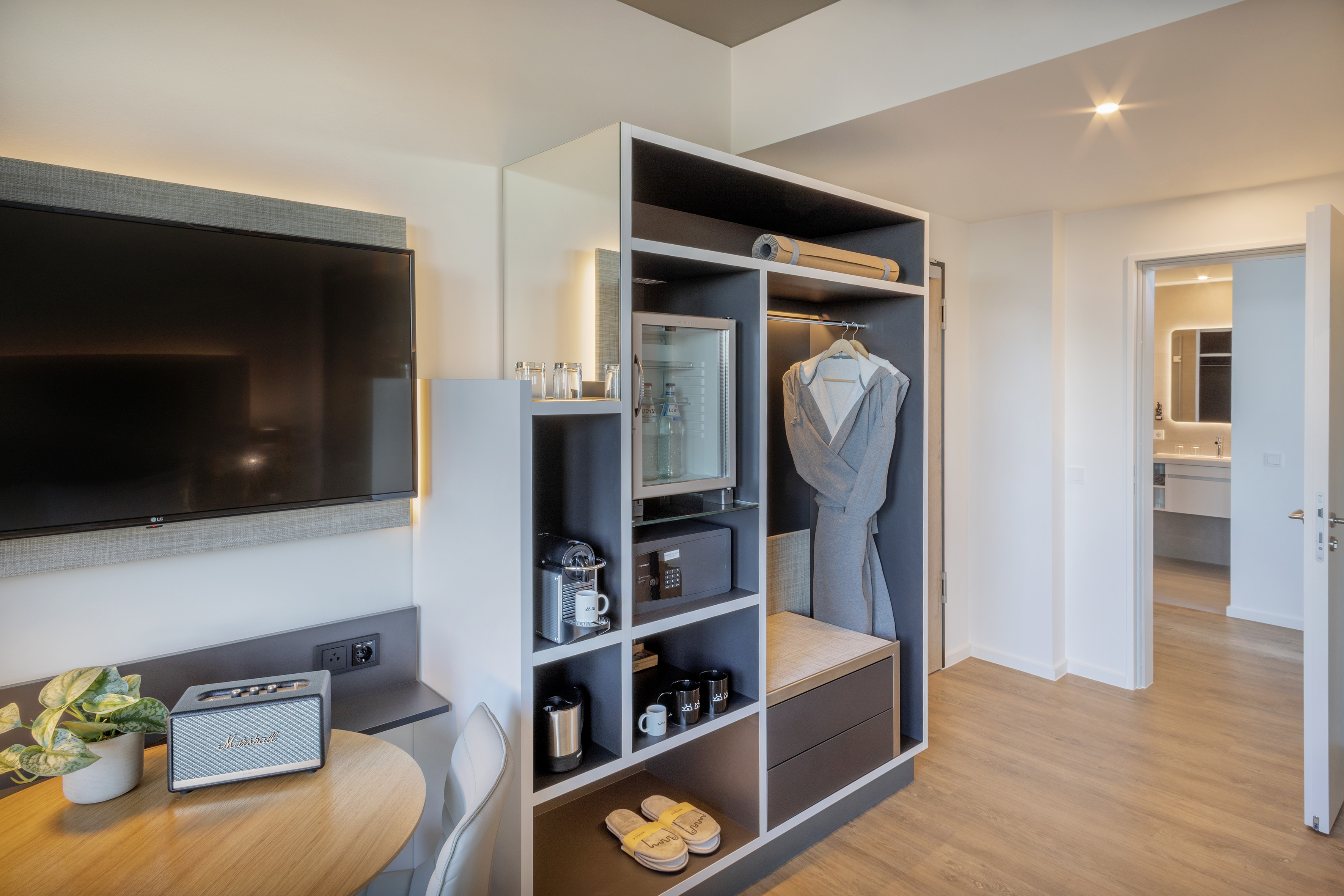 Modern hotel room with TV, integrated wardrobe, mini-bar, and coffee machine. - The Townhouse - INNSiDE Luxembourg, Luxemburg
