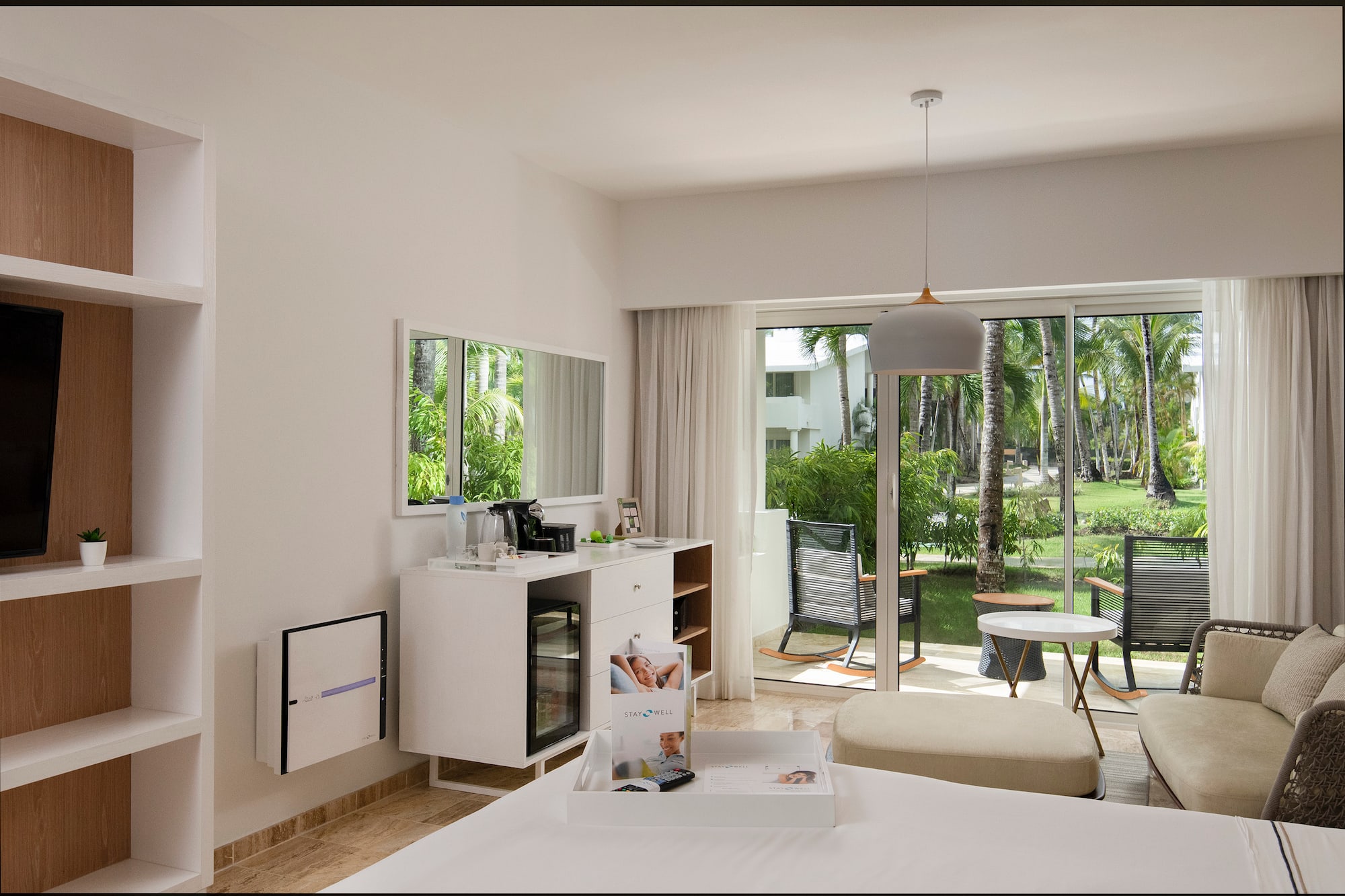 a room with a bed and a table and chairs and a sliding glass door