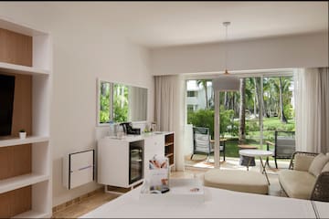 a room with a bed and a table and chairs and a sliding glass door