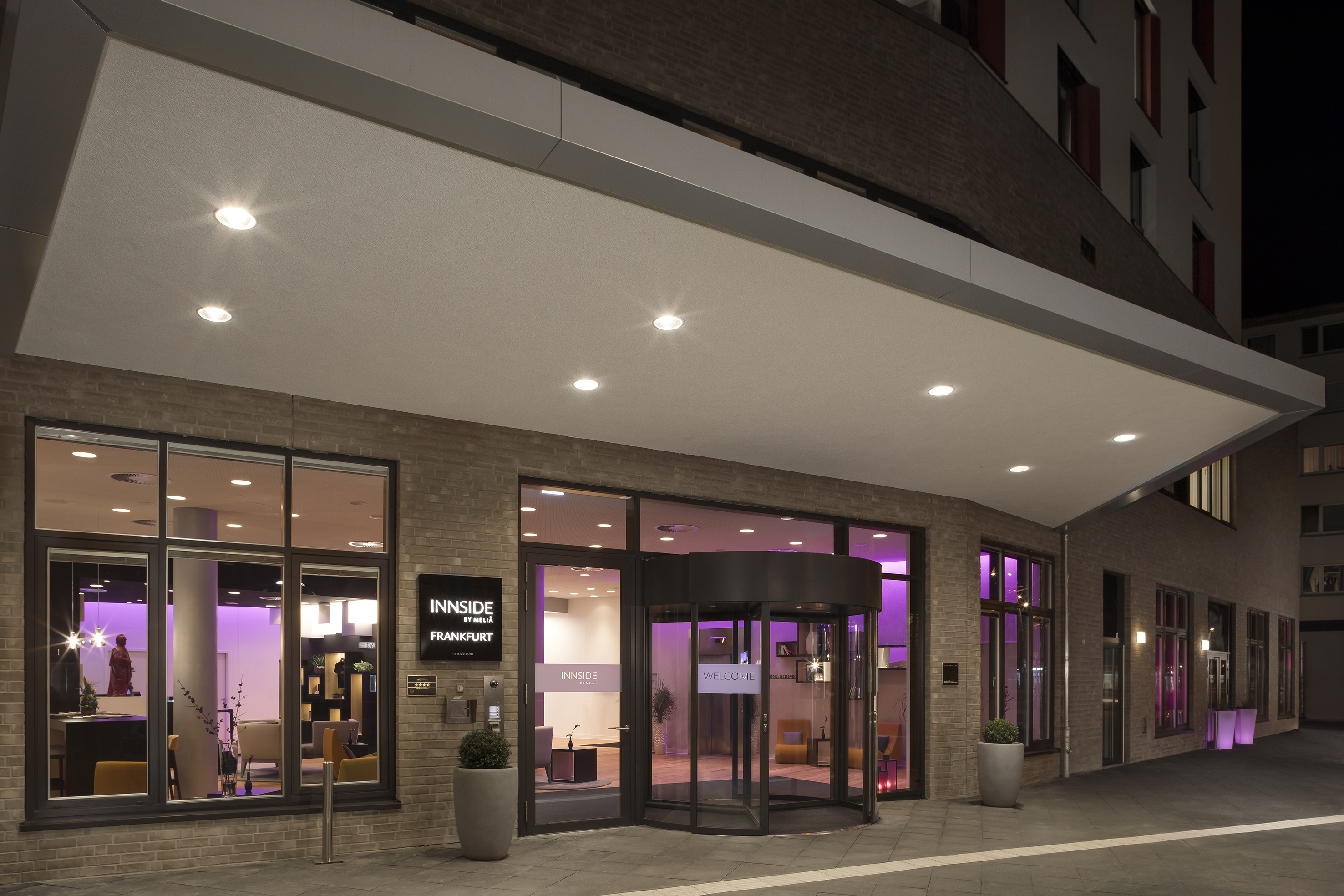 INNSIDE by MELIÁ Frankfurt hotel entrance at night, modern purple-lit lobby.