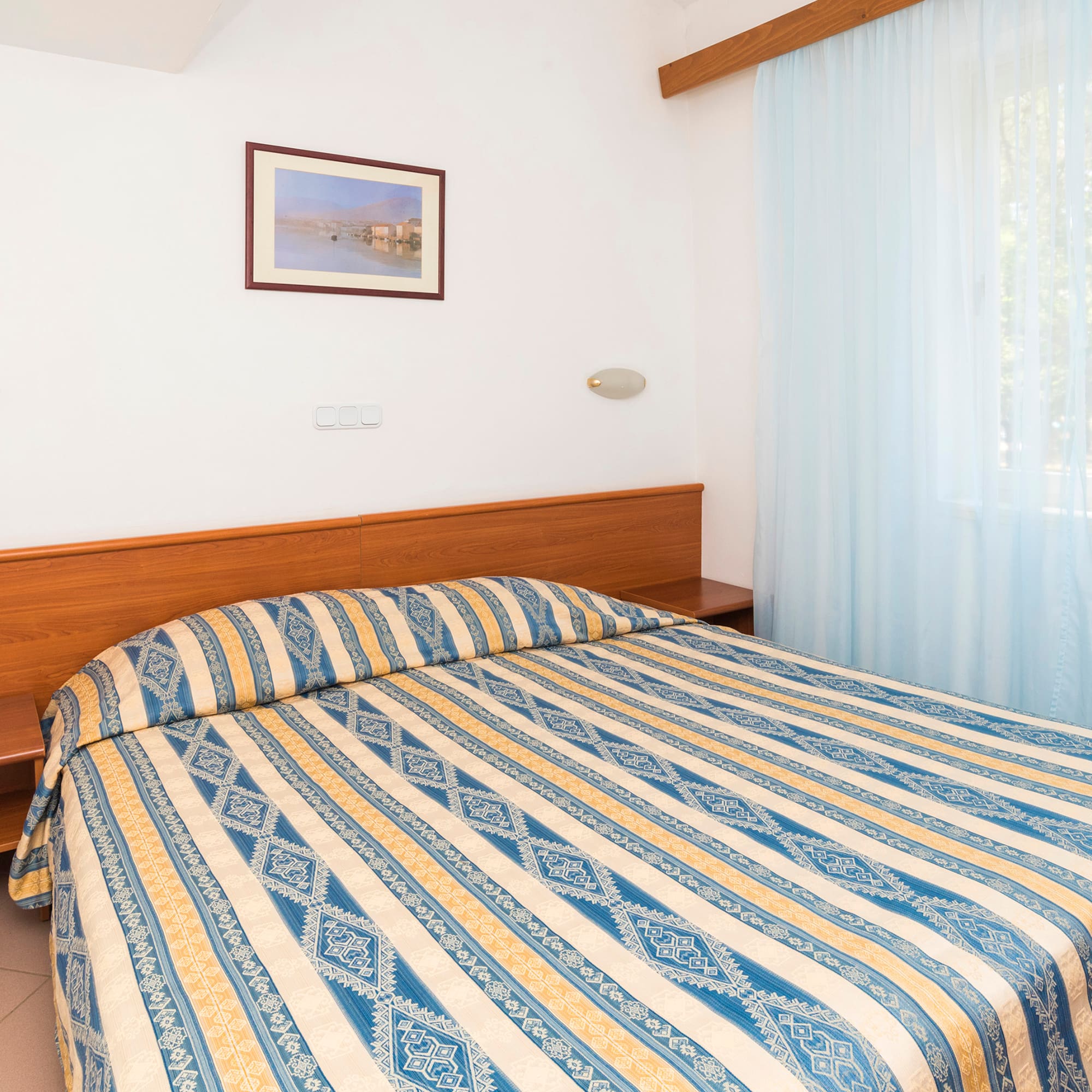 a bed with a wood headboard and a lamp in a room