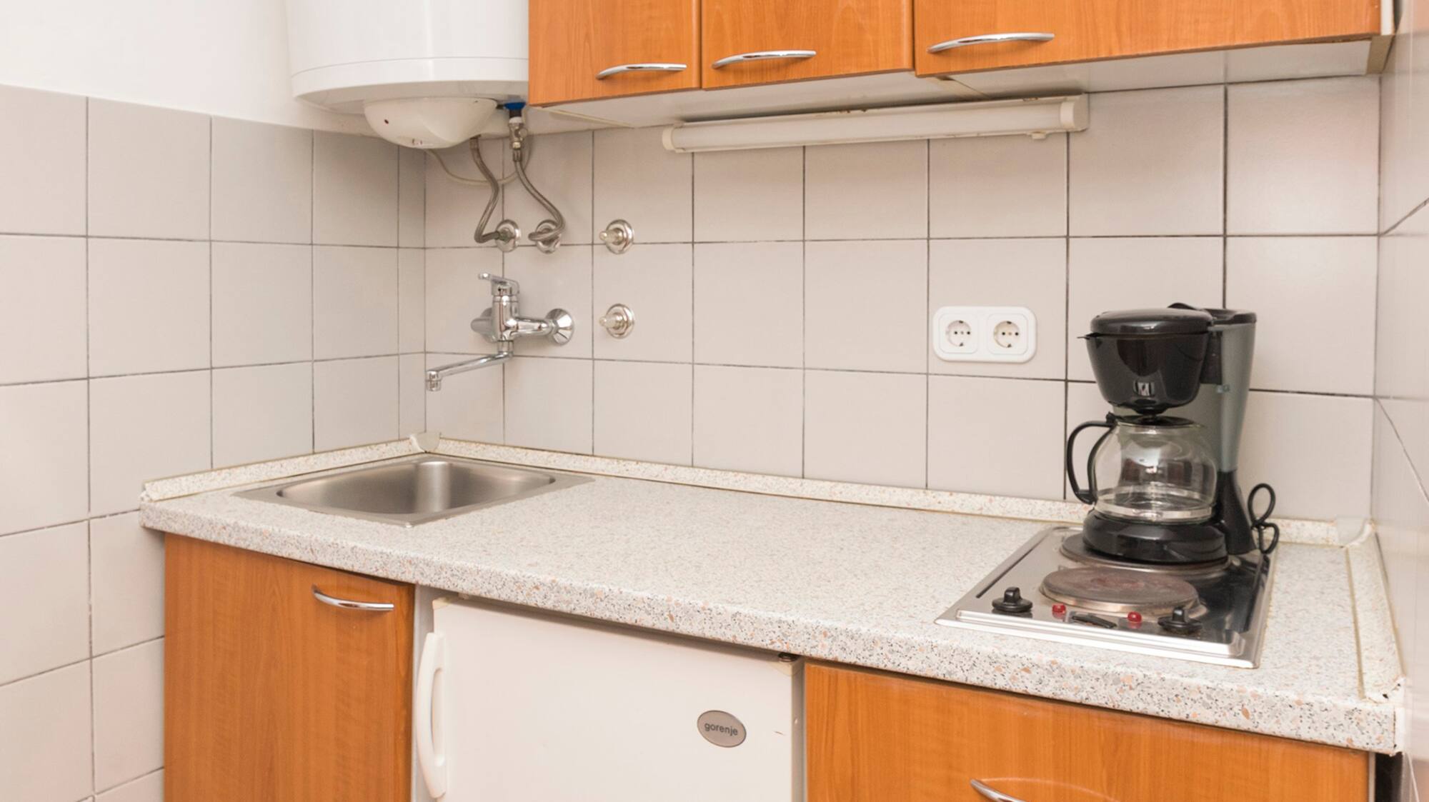 a kitchen with a sink and a coffee maker