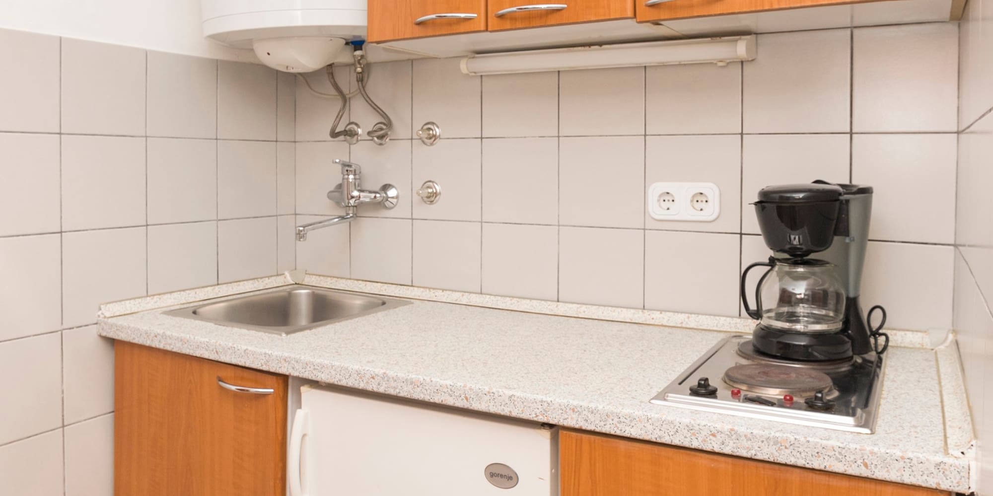 a kitchen with a sink and a coffee maker