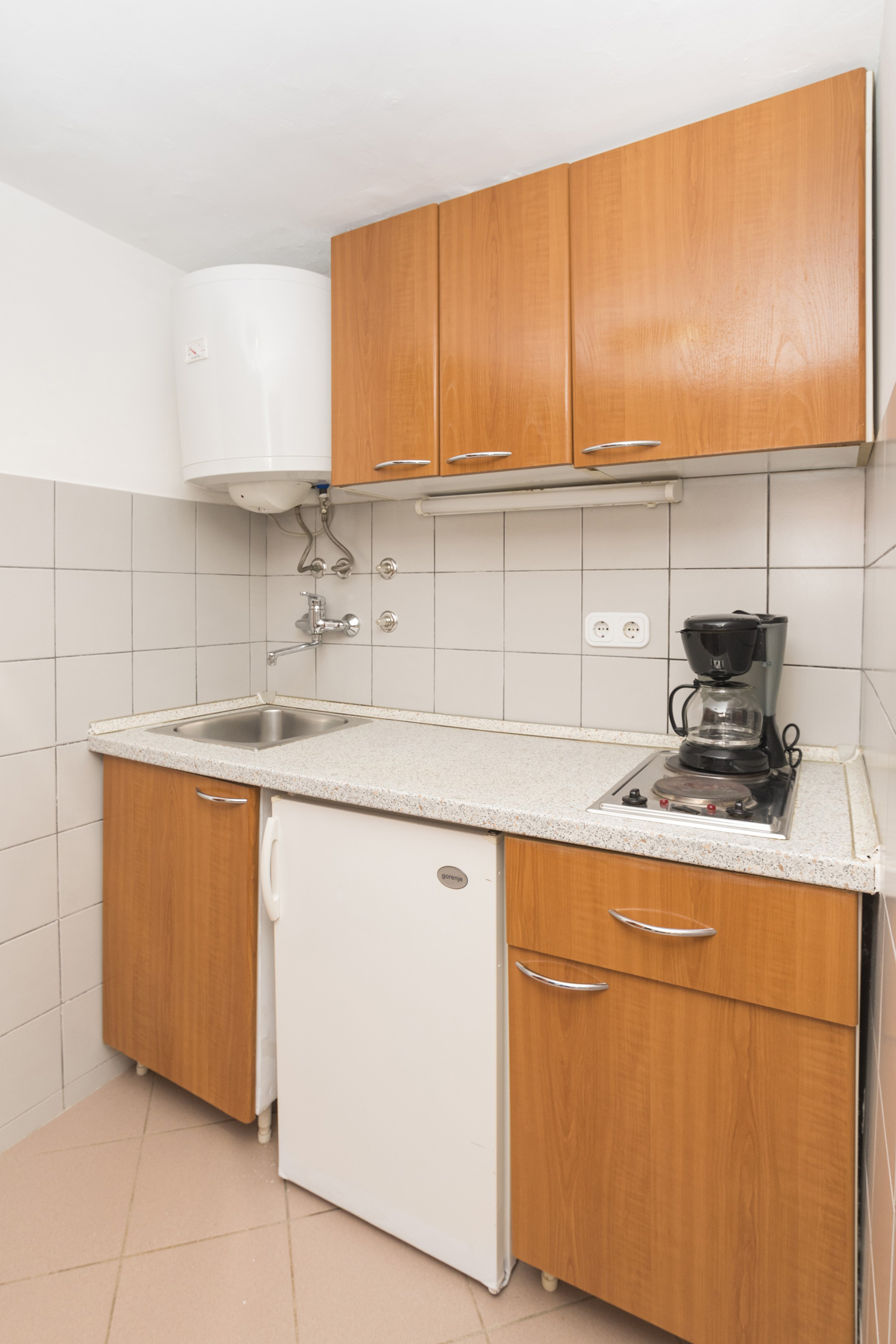 a kitchen with a sink and a coffee maker
