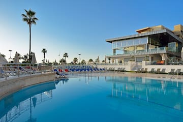 a pool with chairs and a building