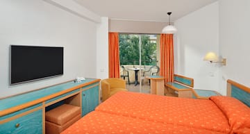 a room with two beds and a television