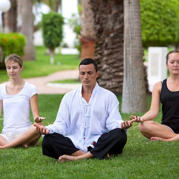 a group of people meditating in the grass
