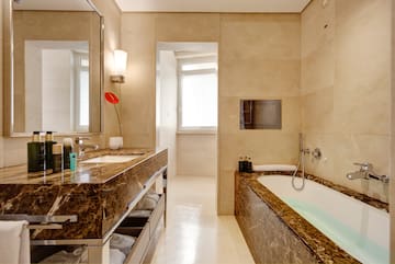 a bathroom with marble counter tops and a tub