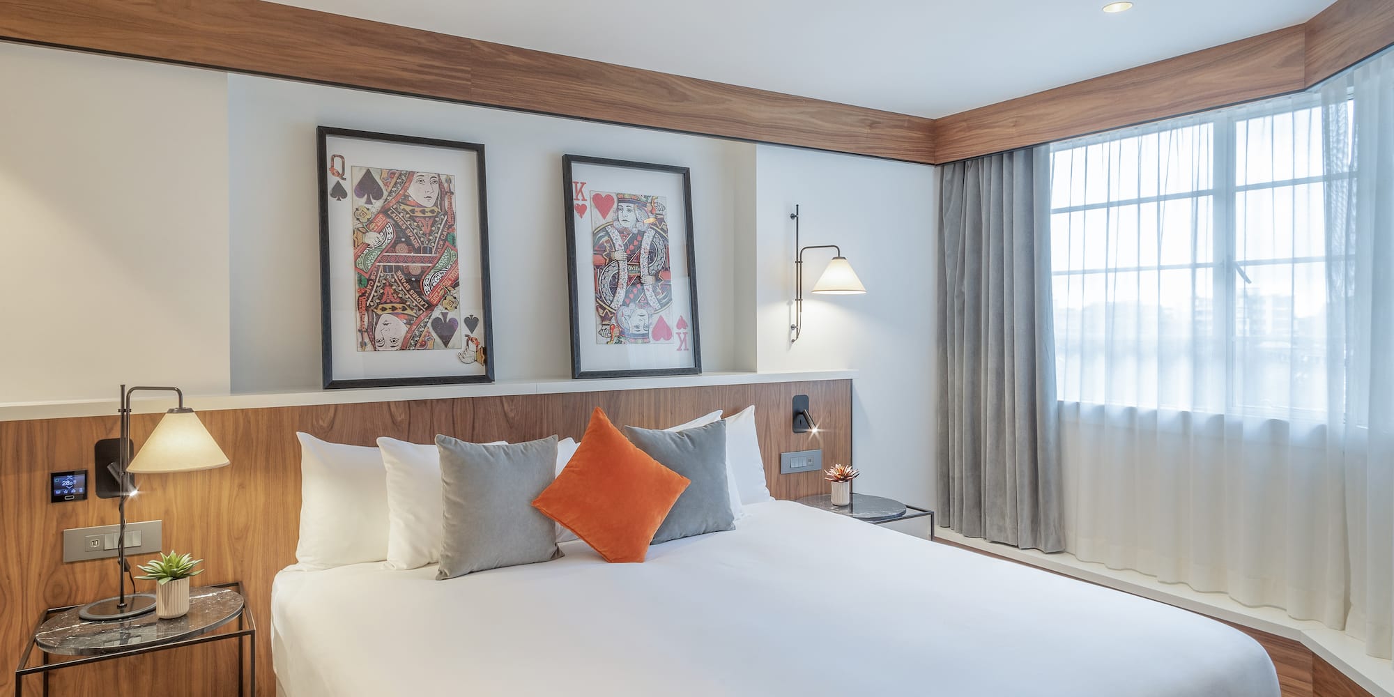 a bed with pillows and a table with two pictures on the wall