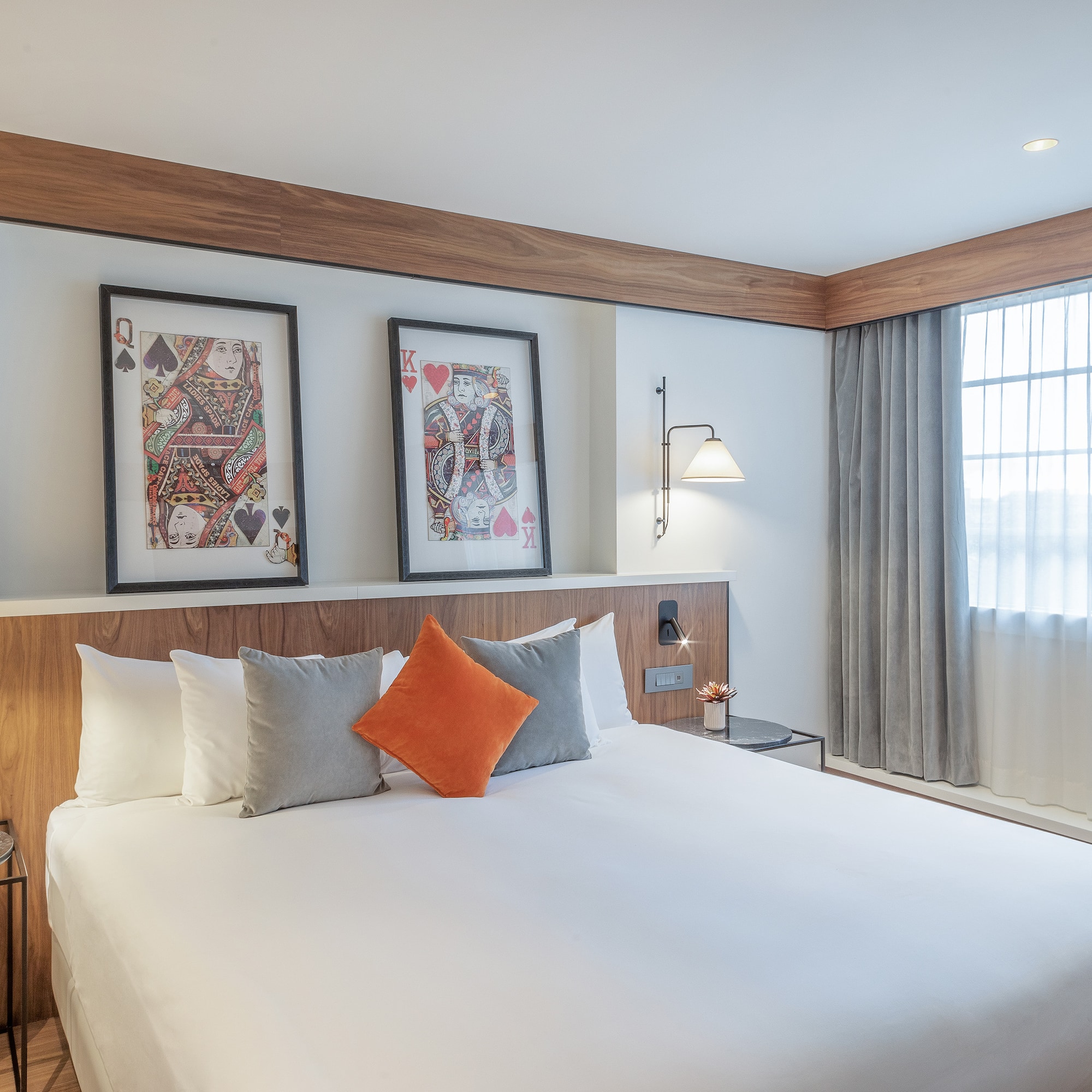 a bed with pillows and a table with two pictures on the wall