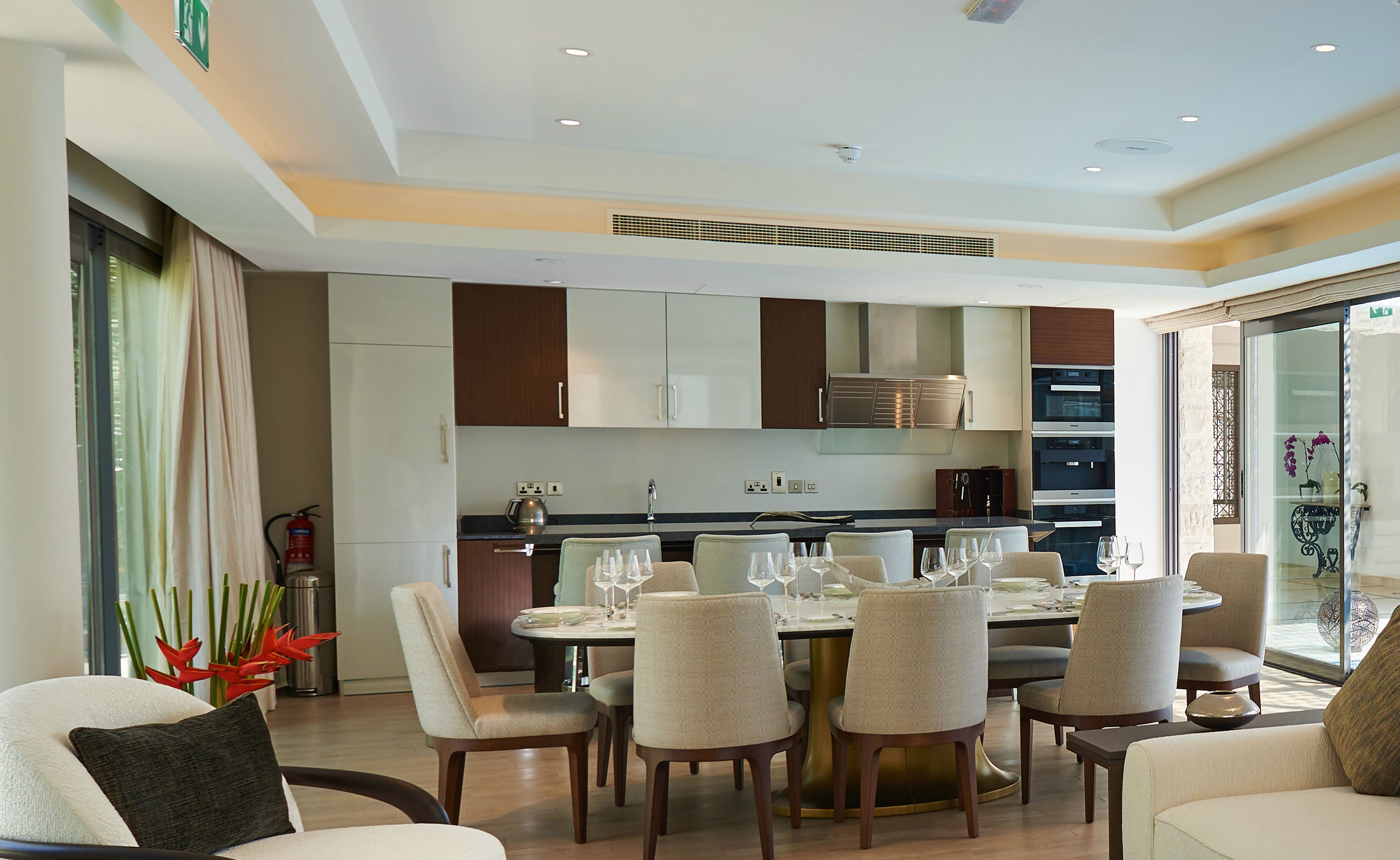 Modern open-plan kitchen dining room, large table, two-tone cabinets.