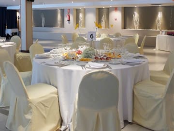 a round table with white cloths and plates and glasses