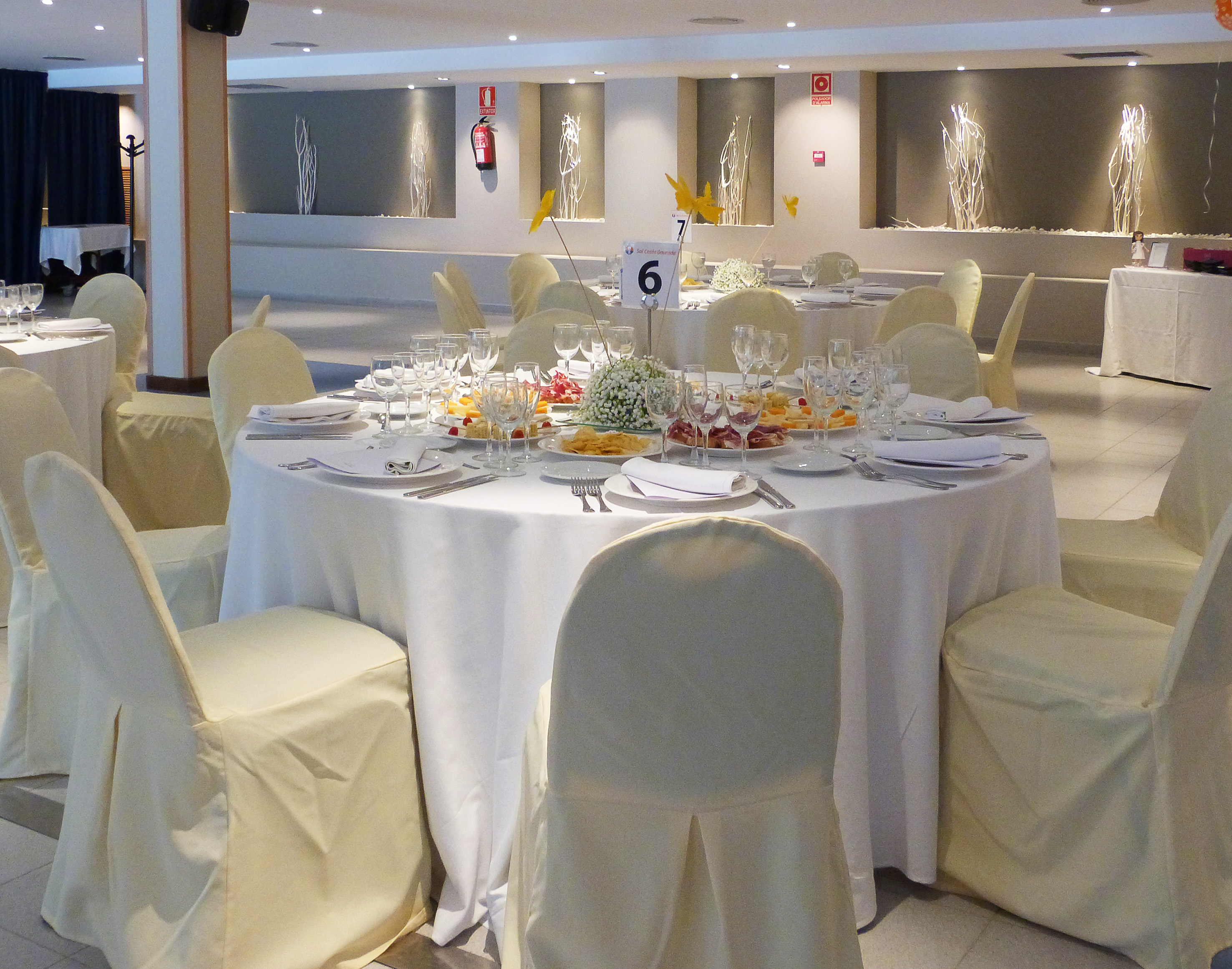 a round table with white cloths and plates and glasses