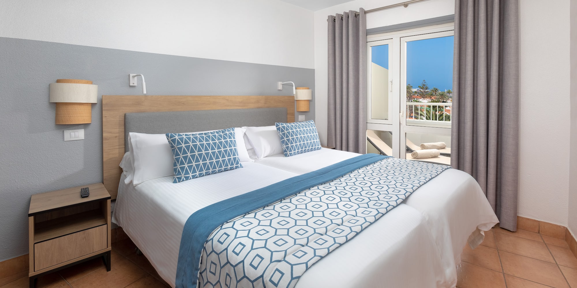 a bed with pillows and a door to a balcony