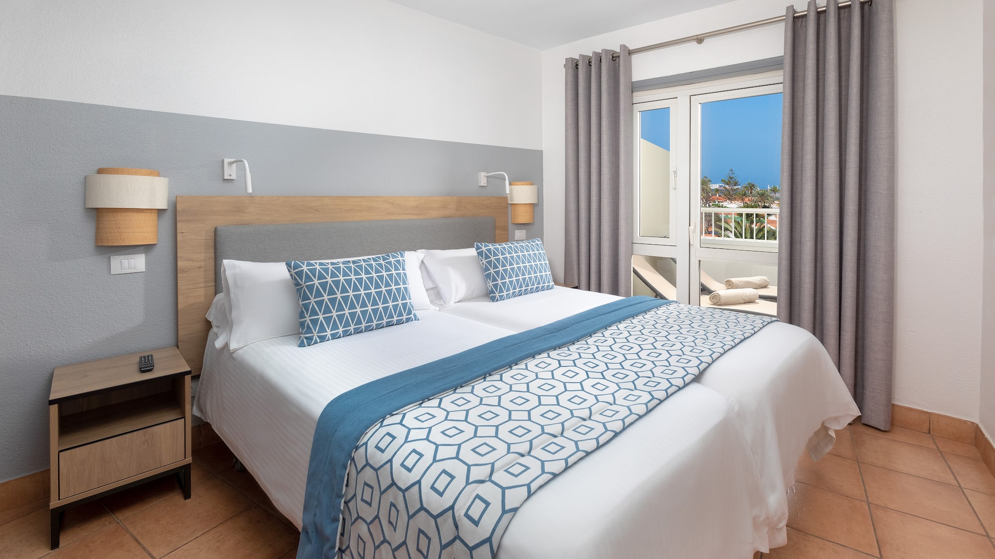 a bed with pillows and a door to a balcony