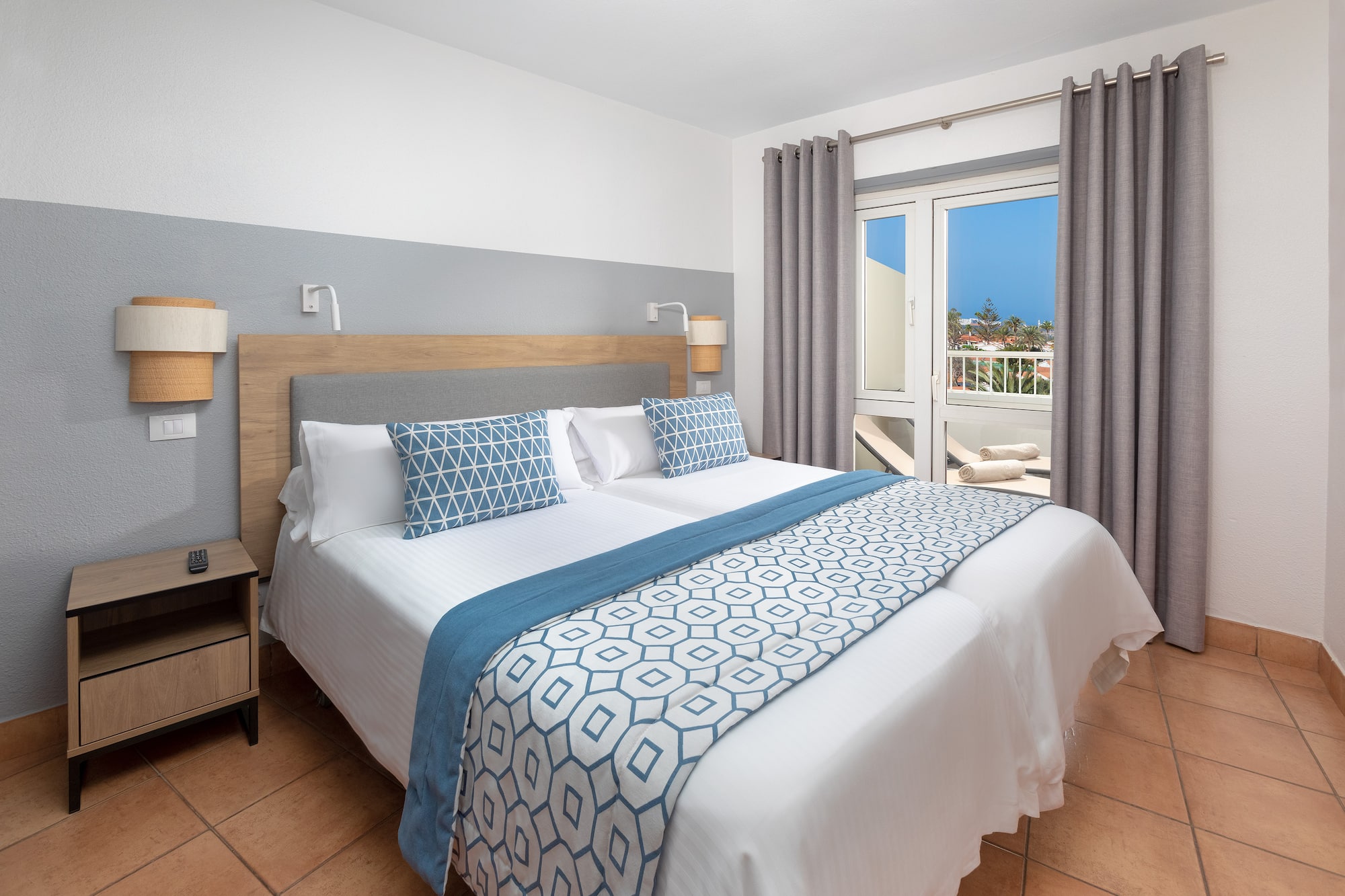 a bed with pillows and a door to a balcony