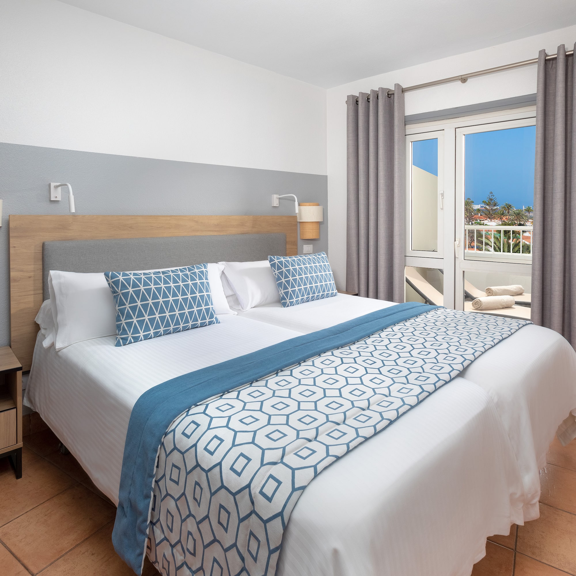 a bed with pillows and a door to a balcony