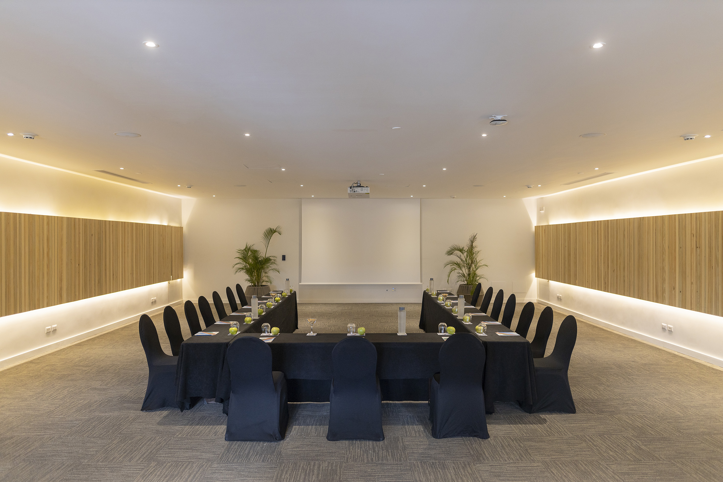 Modern U-shaped conference room with projector for corporate events.