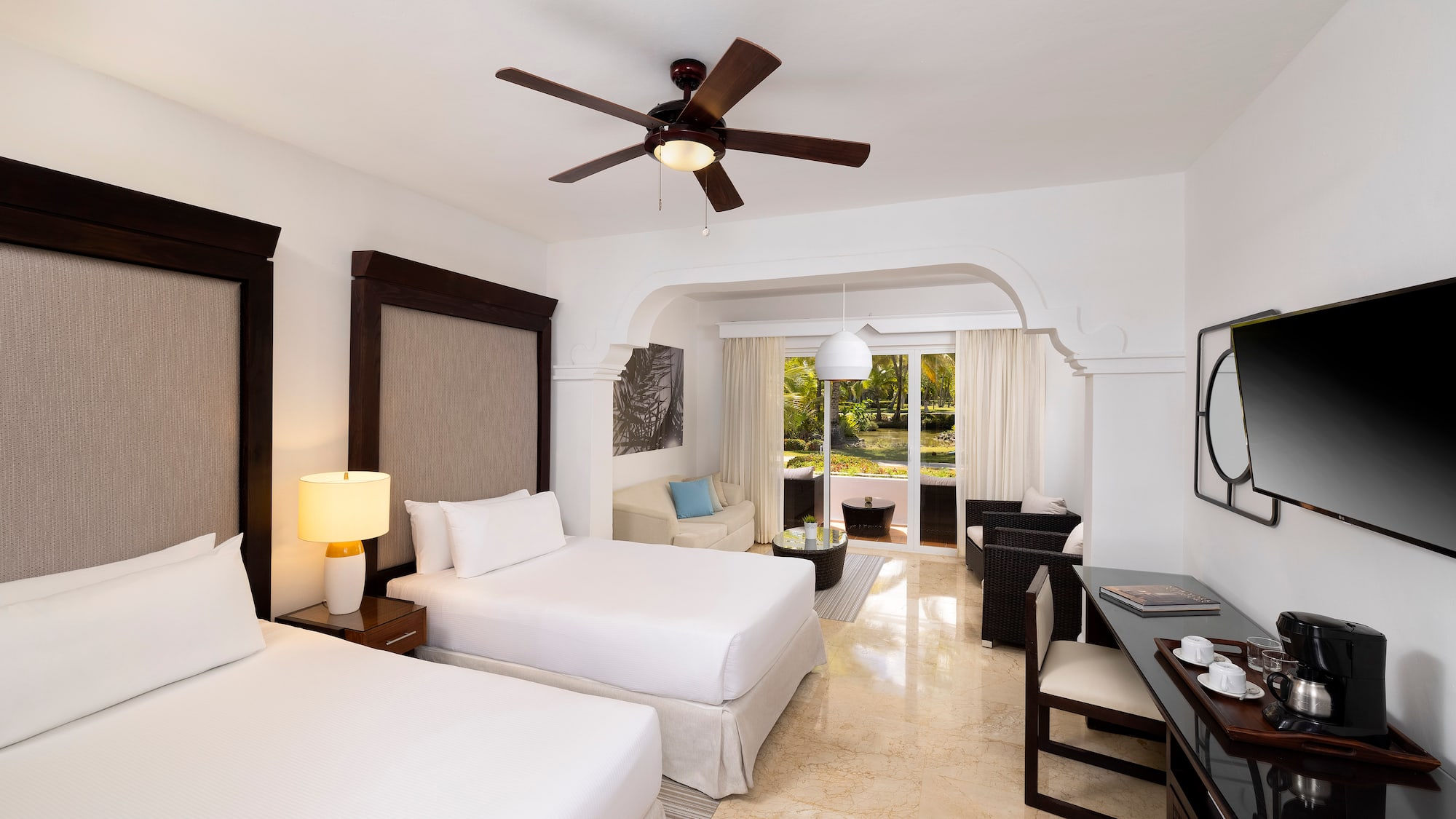 a room with two beds and a ceiling fan