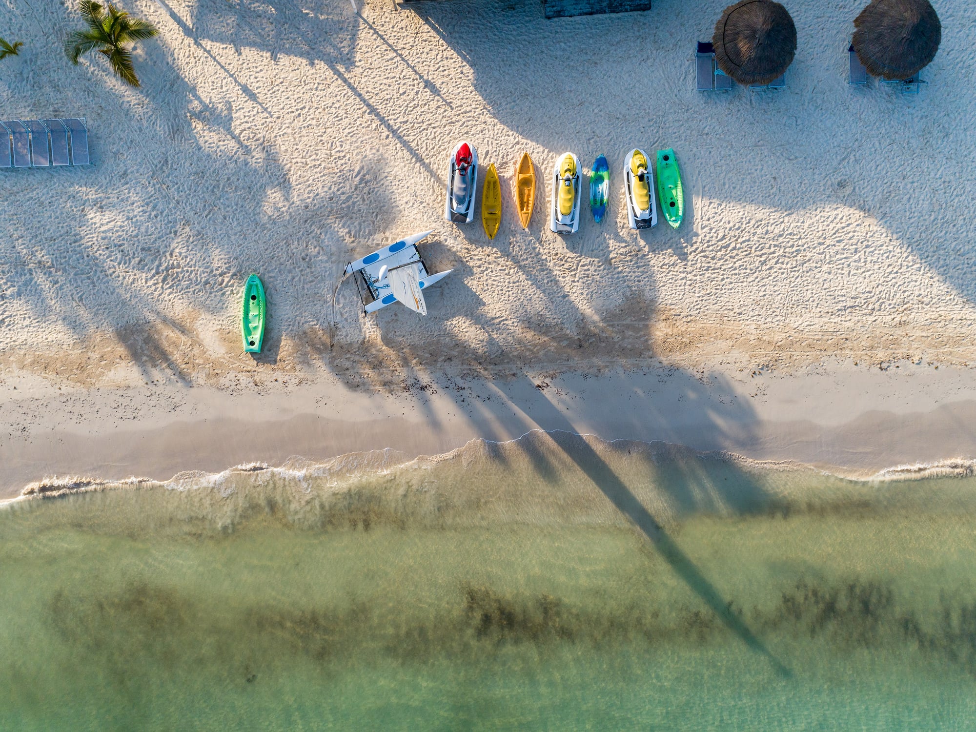 a beach with boats and a plane