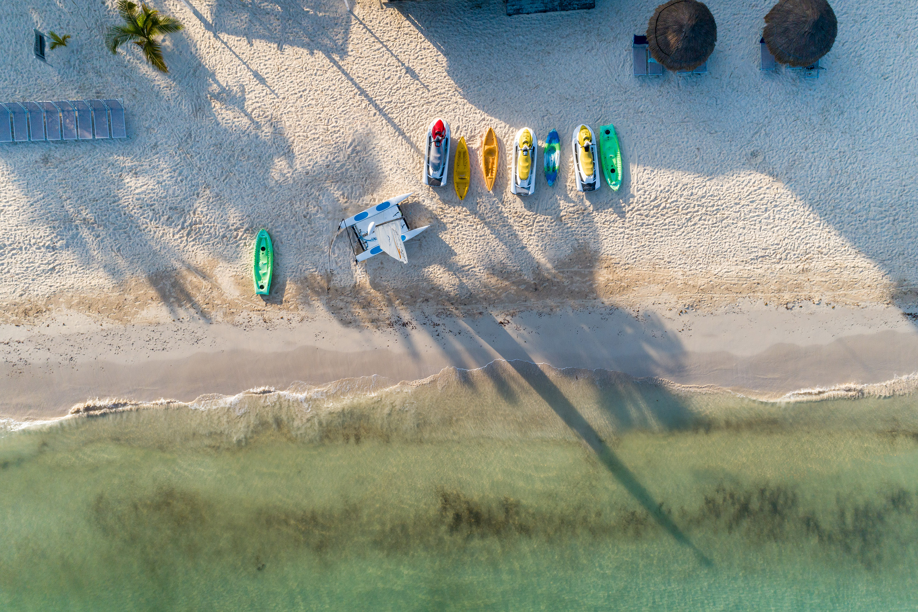 a beach with boats and a plane