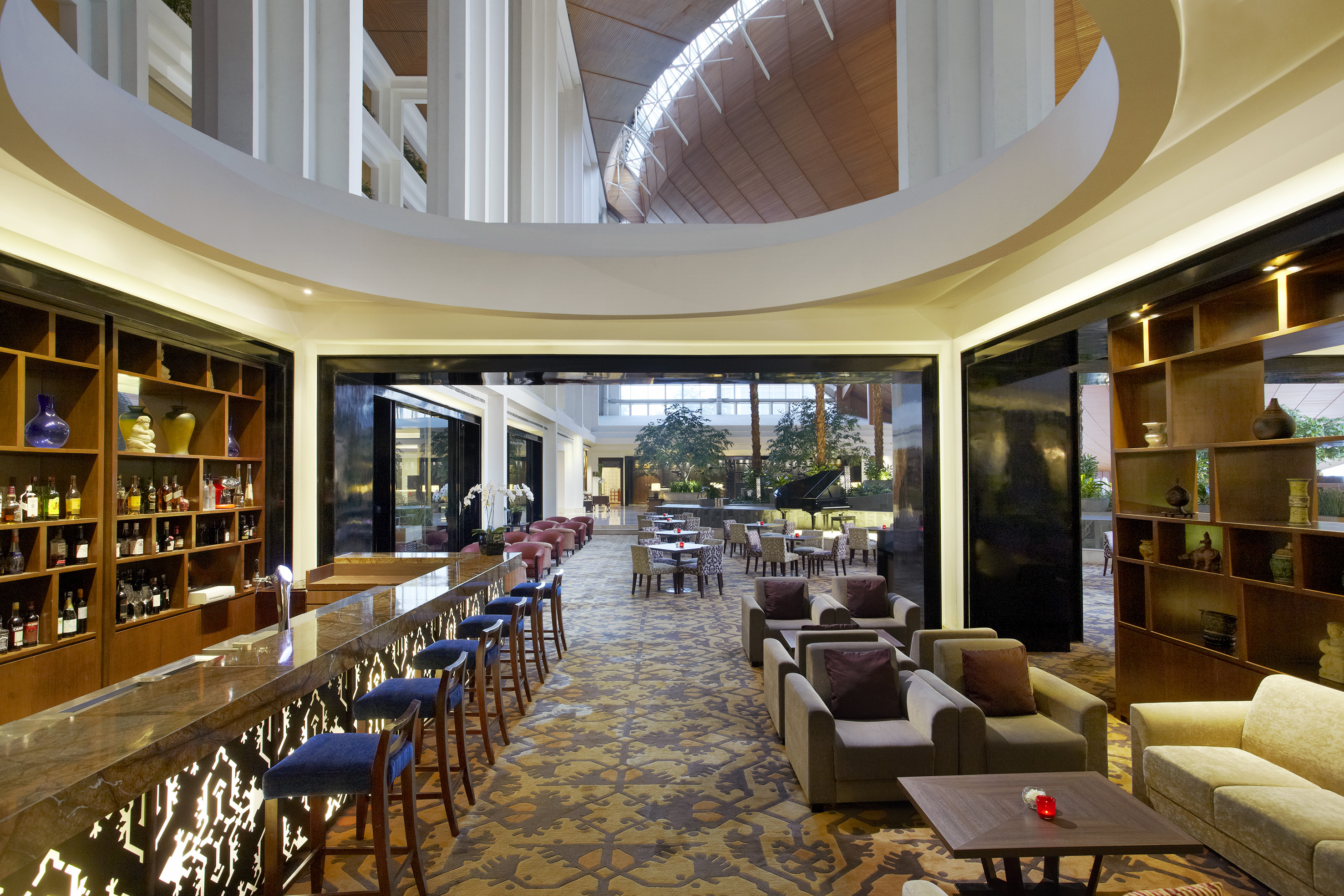 Luxurious hotel bar and lounge with plush seating and grand atrium.