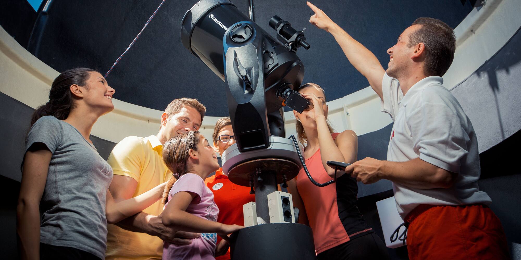 a group of people looking at a telescope