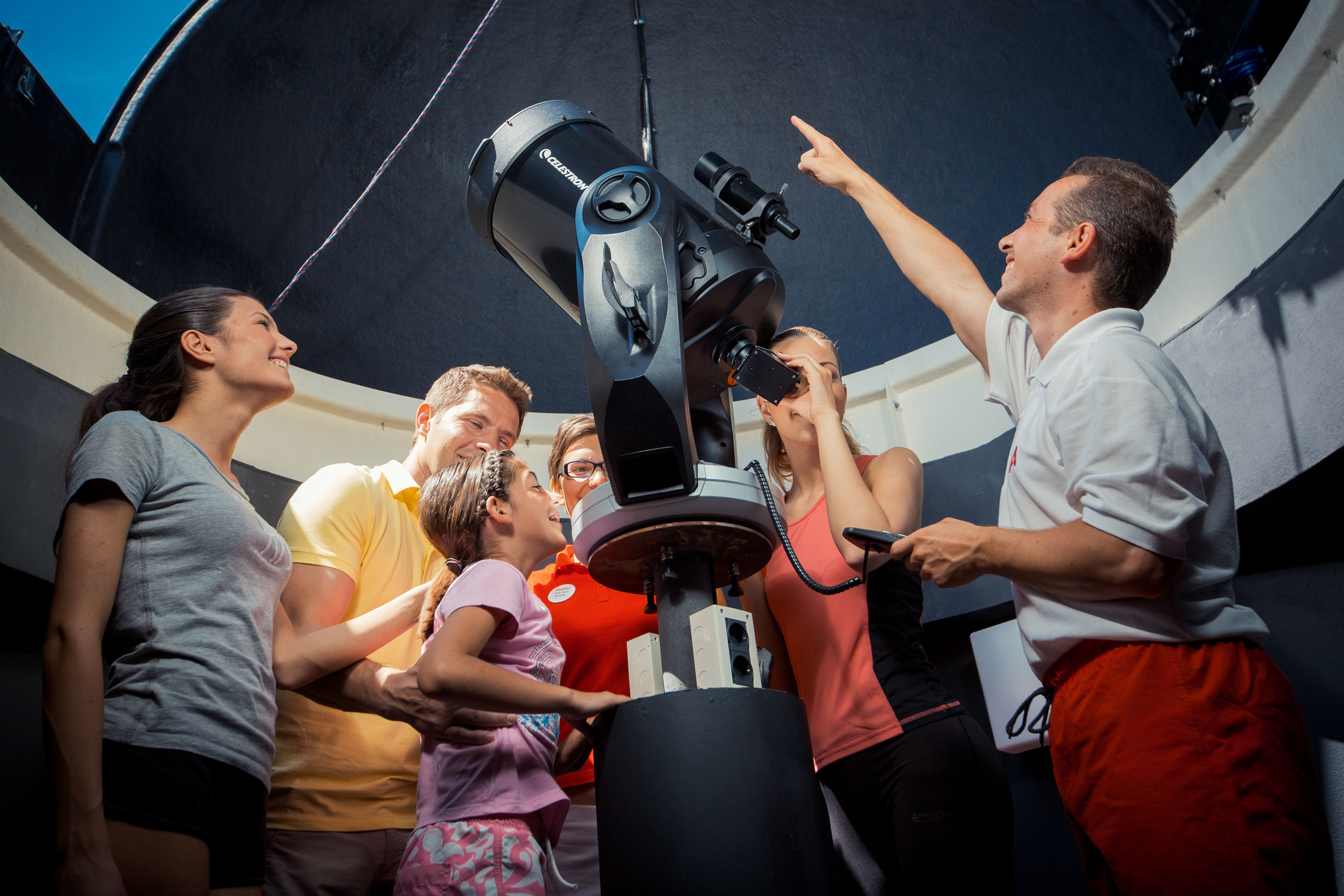 a group of people looking at a telescope