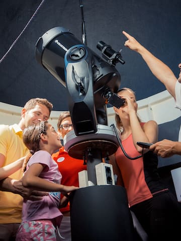 a group of people looking at a telescope