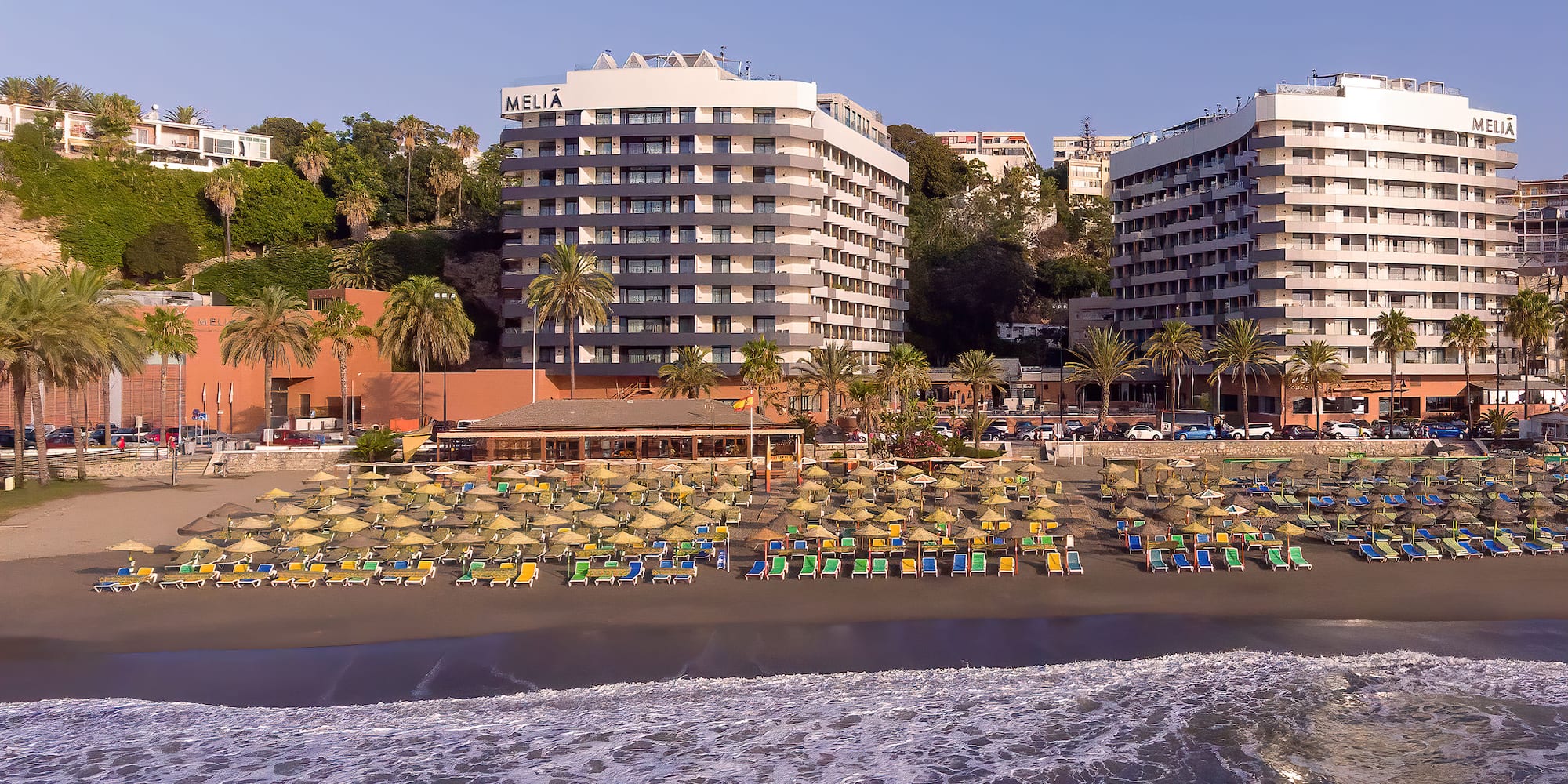 a beach with chairs and a body of water