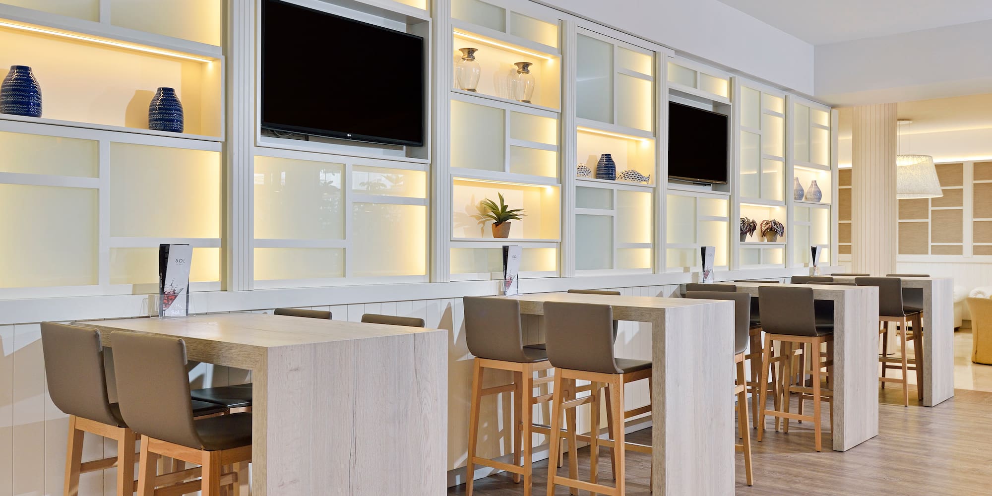 a room with white cabinets and tvs