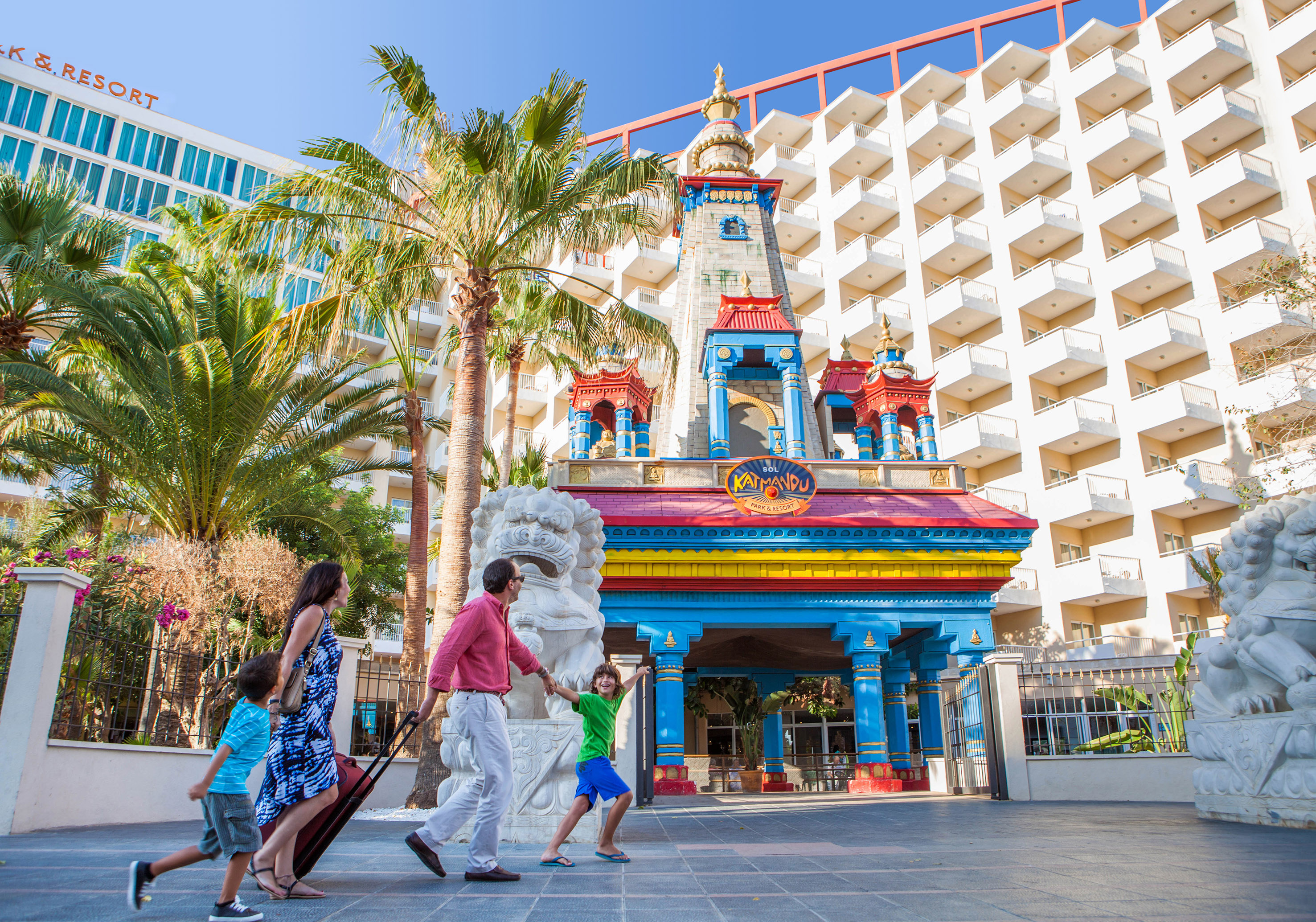 Family arriving at Sol Katmandu Park & Resort entrance, hotel and palm trees.