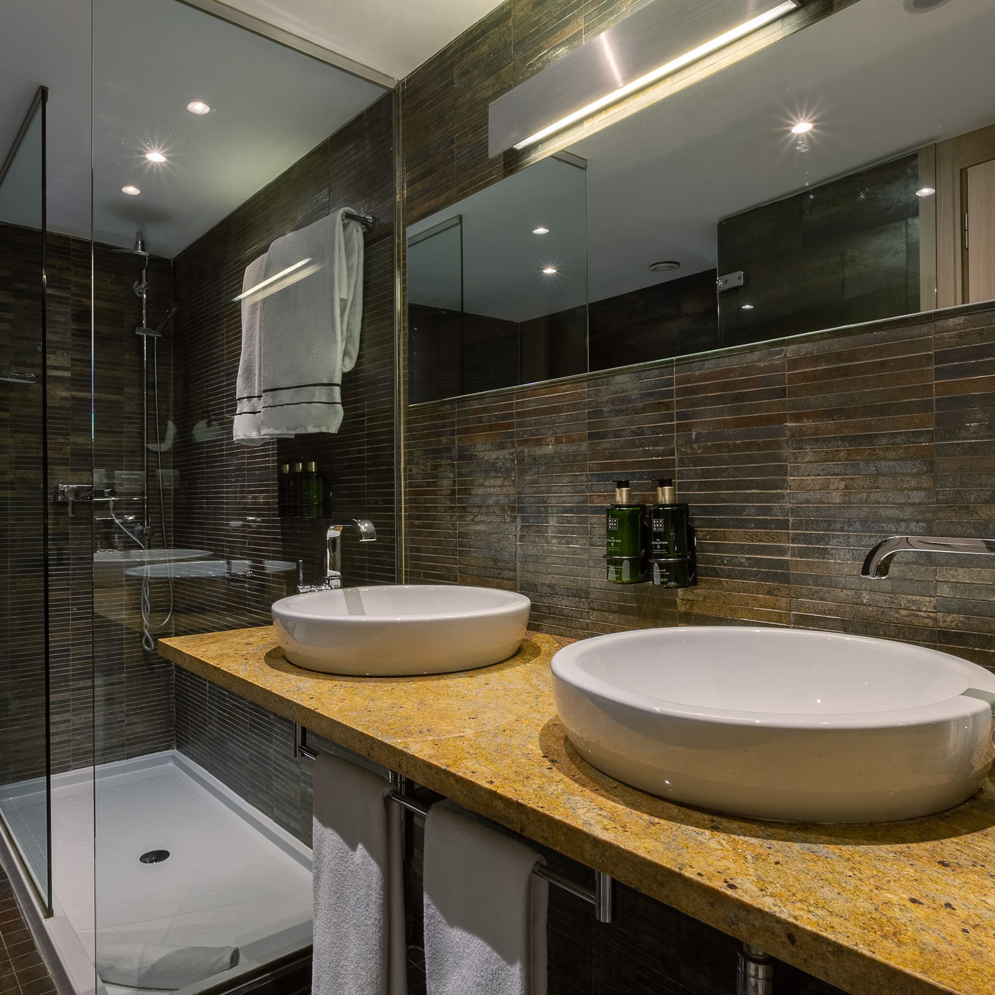 a bathroom with two sinks and a shower