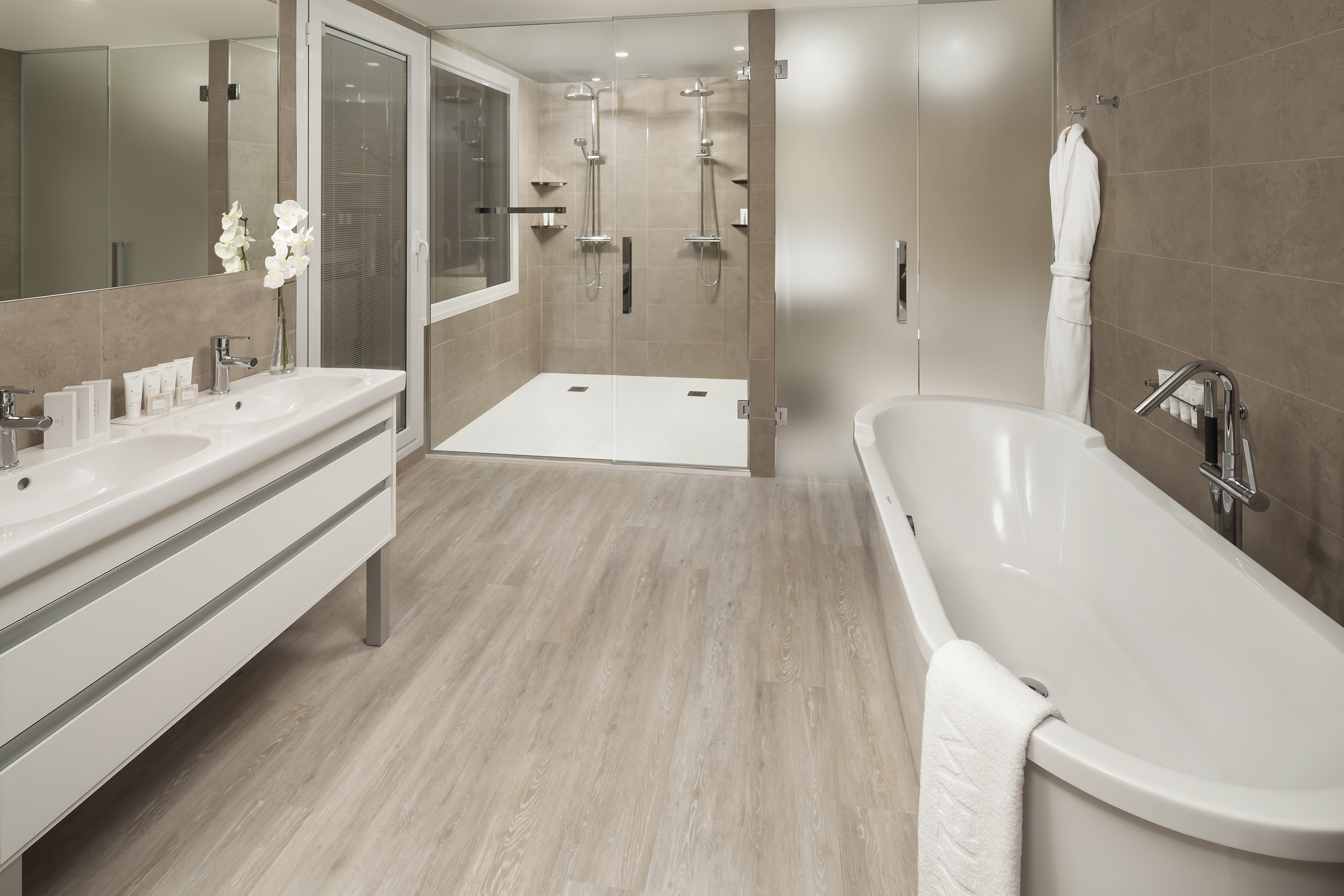 Modern luxury bathroom with double vanity, walk-in shower, and freestanding tub.