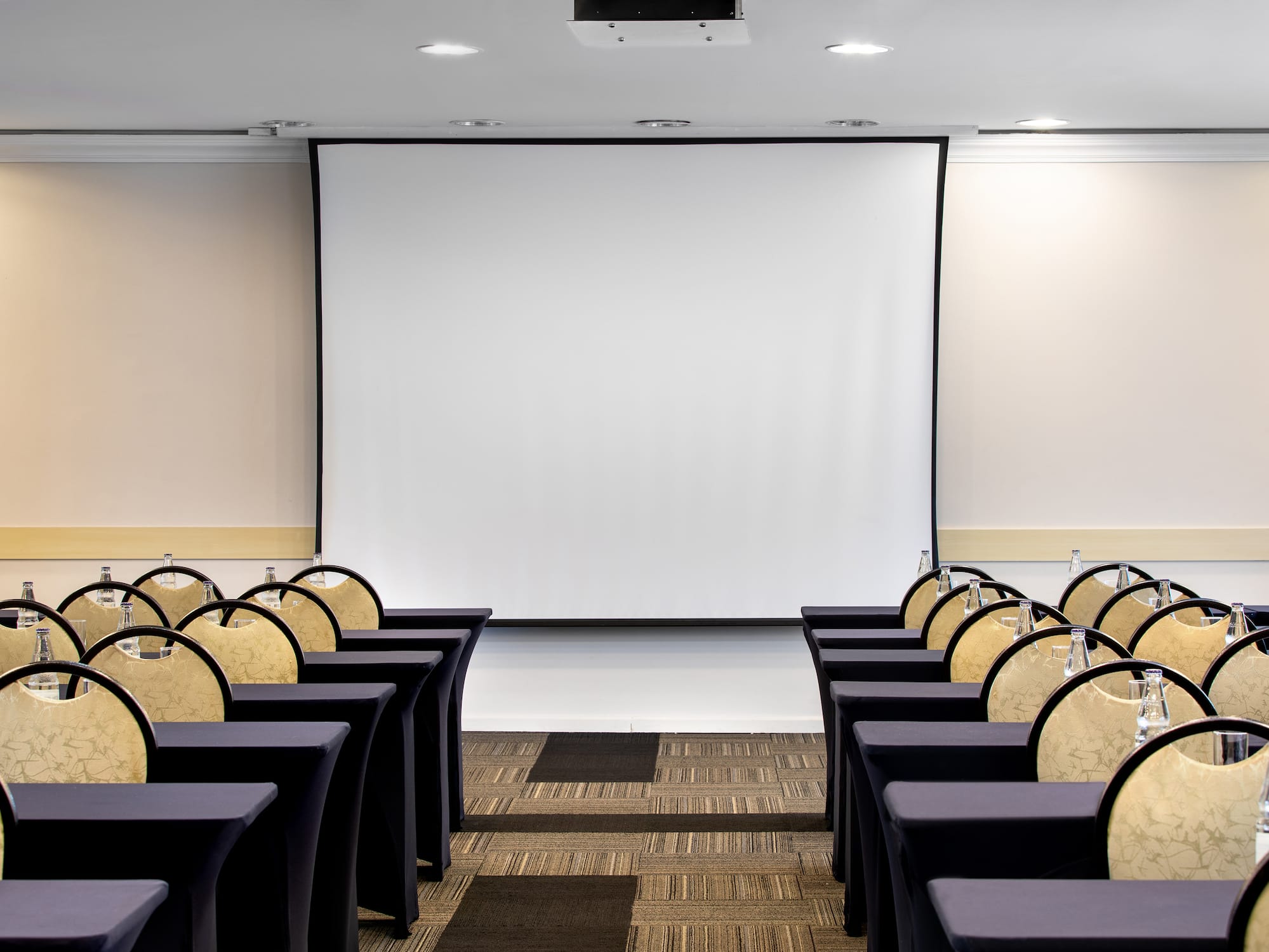 a room with chairs and a projector screen