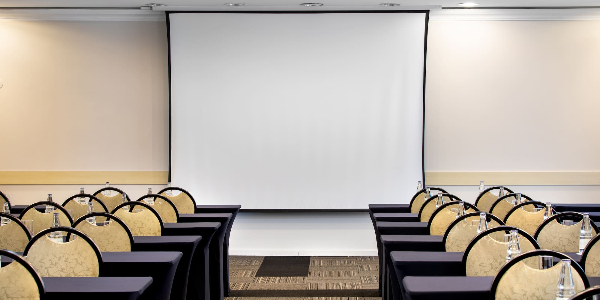 a room with chairs and a projector screen