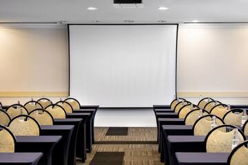 a room with chairs and a projector screen