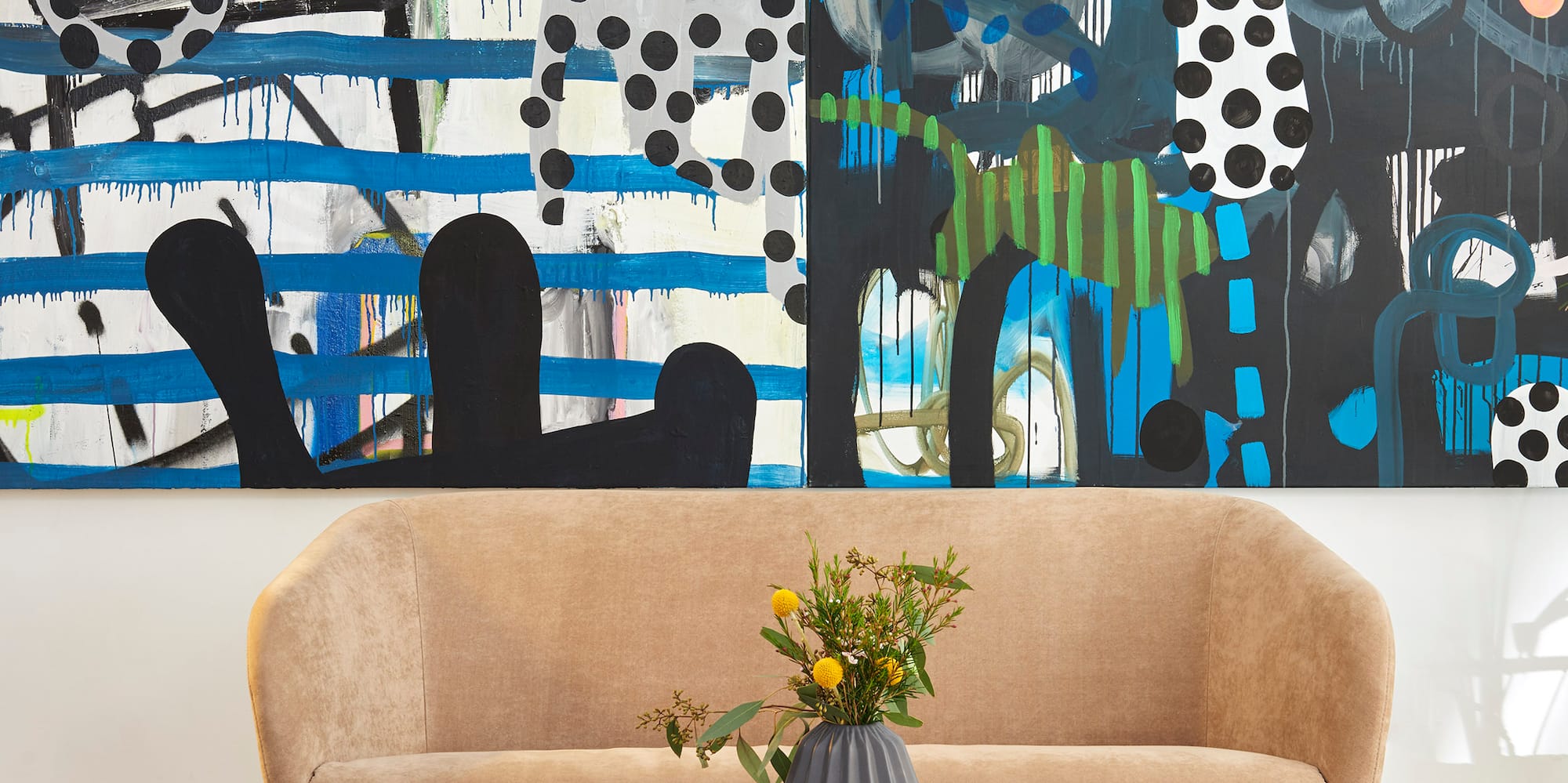 a couch and a coffee table in front of a painting