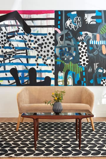 a couch and a coffee table in front of a painting