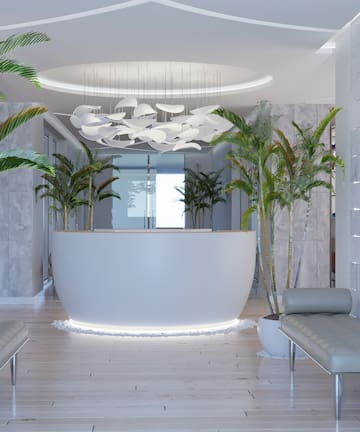 a lobby with a reception desk and palm trees