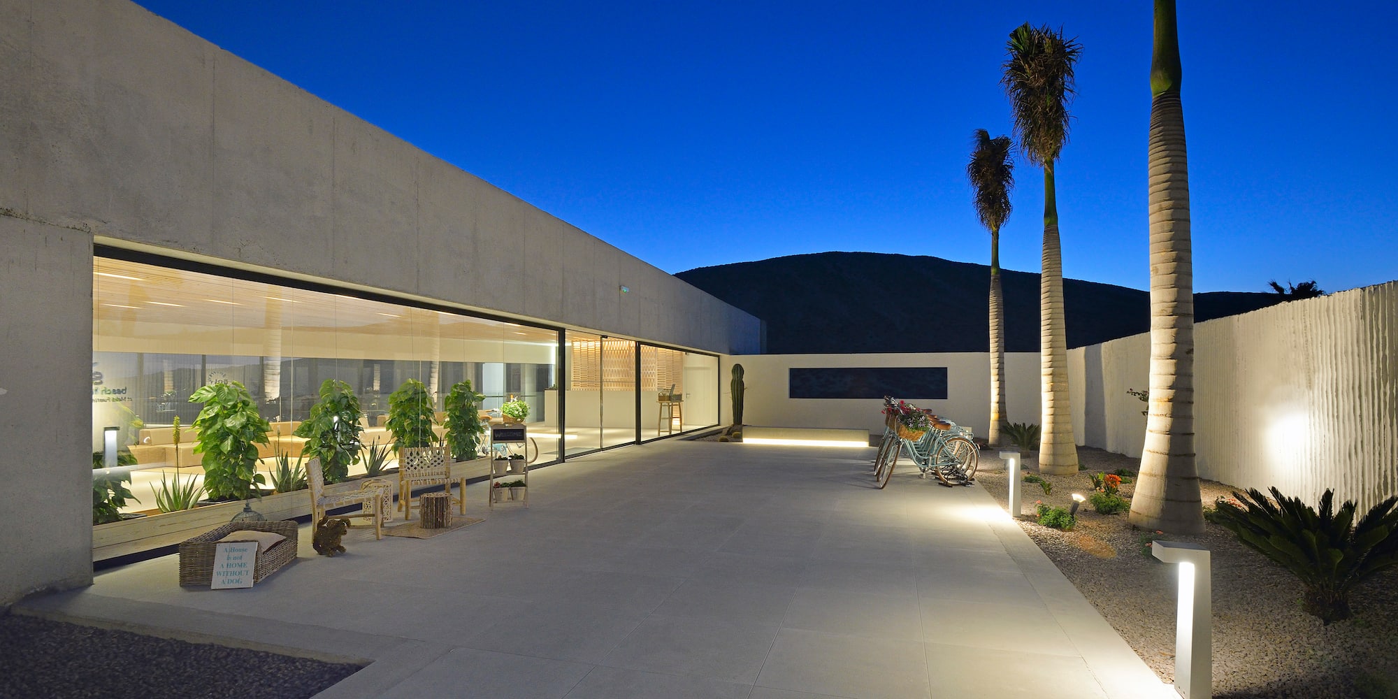 a building with a glass wall and trees