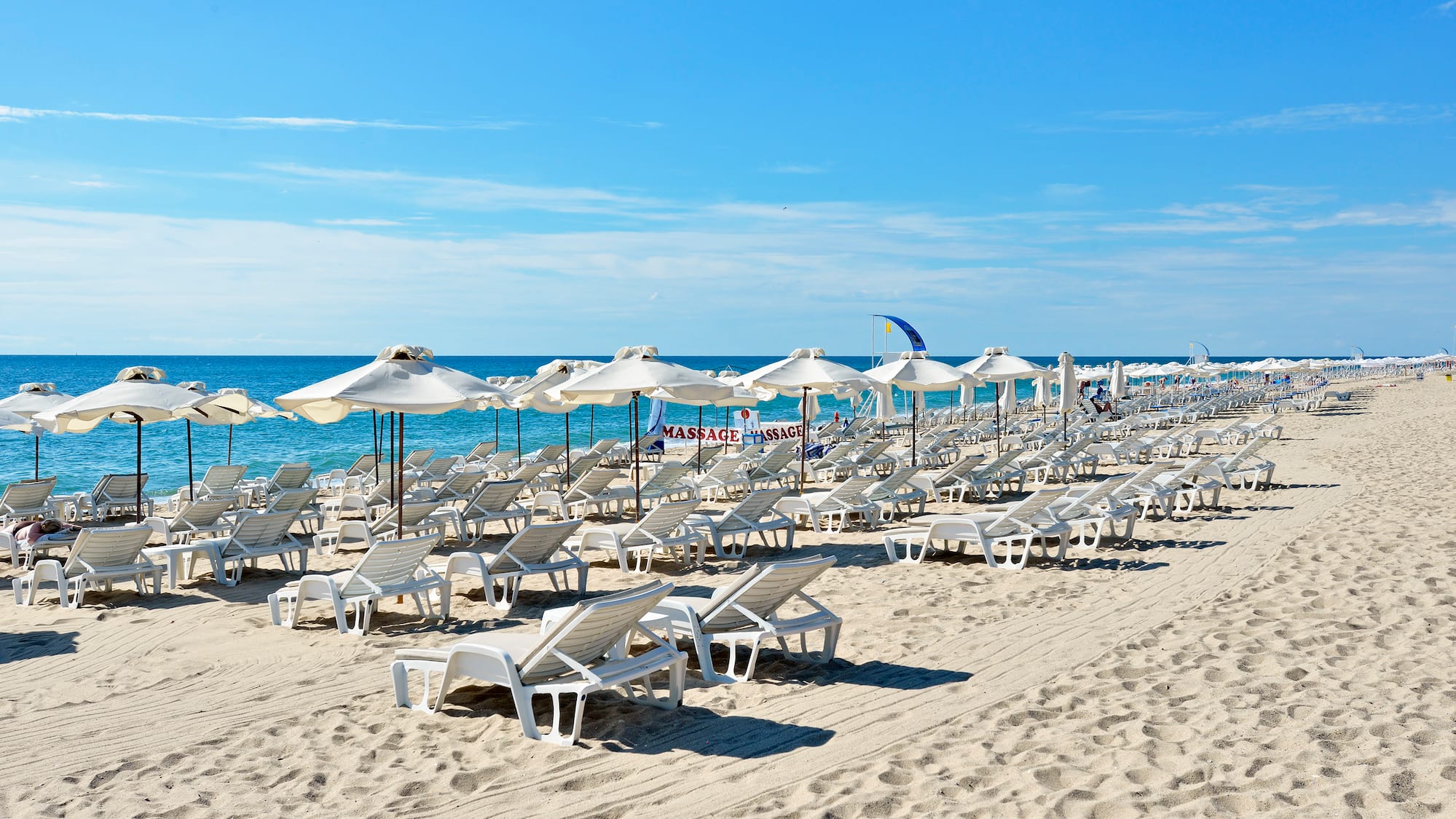 a beach with chairs and umbrellas