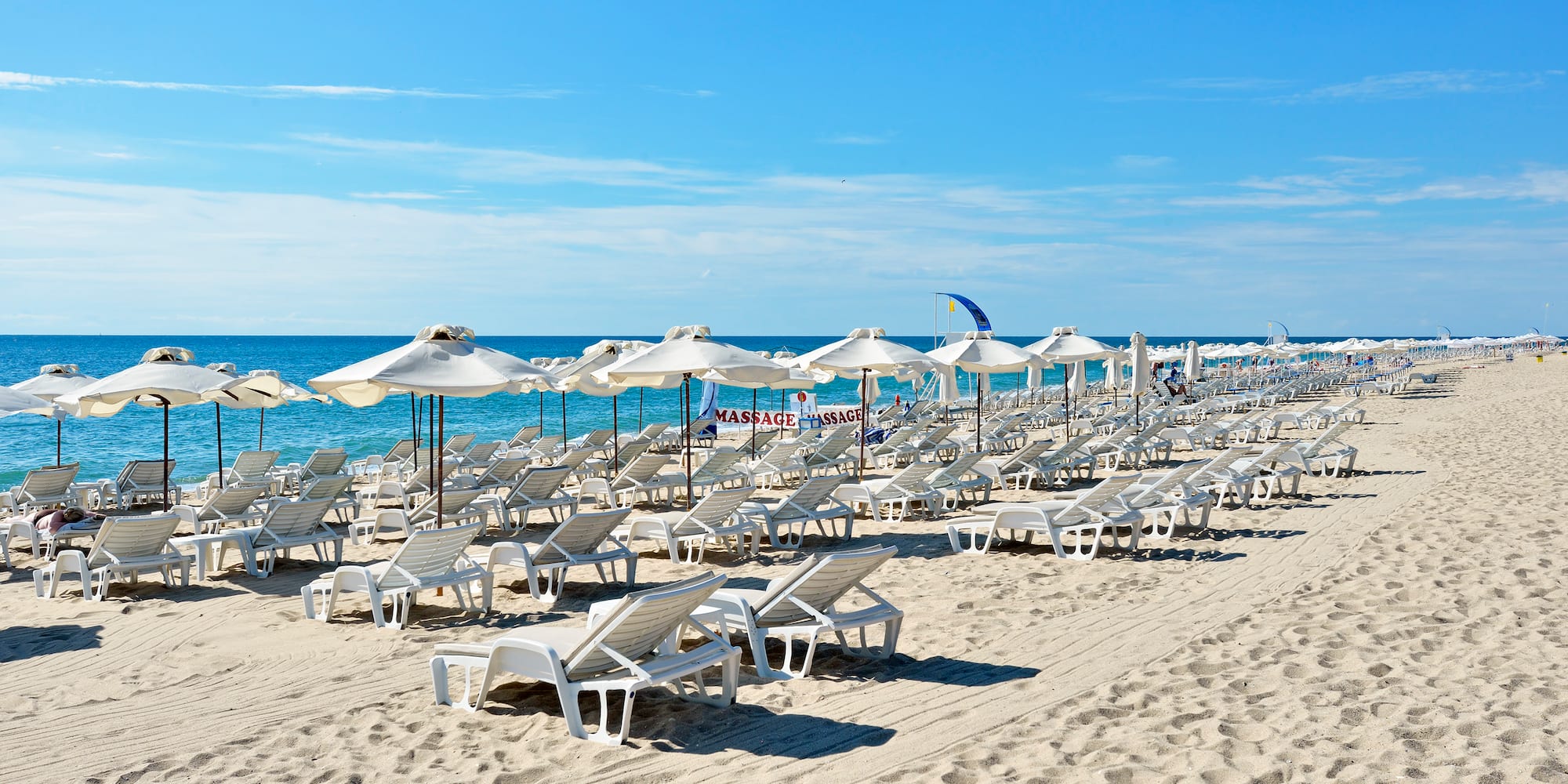 a beach with chairs and umbrellas