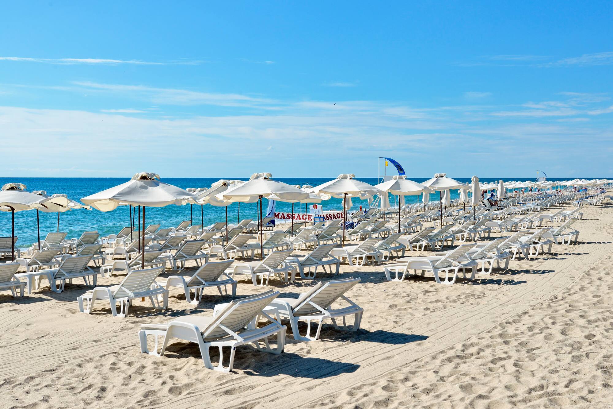 a beach with chairs and umbrellas