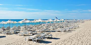 a beach with chairs and umbrellas