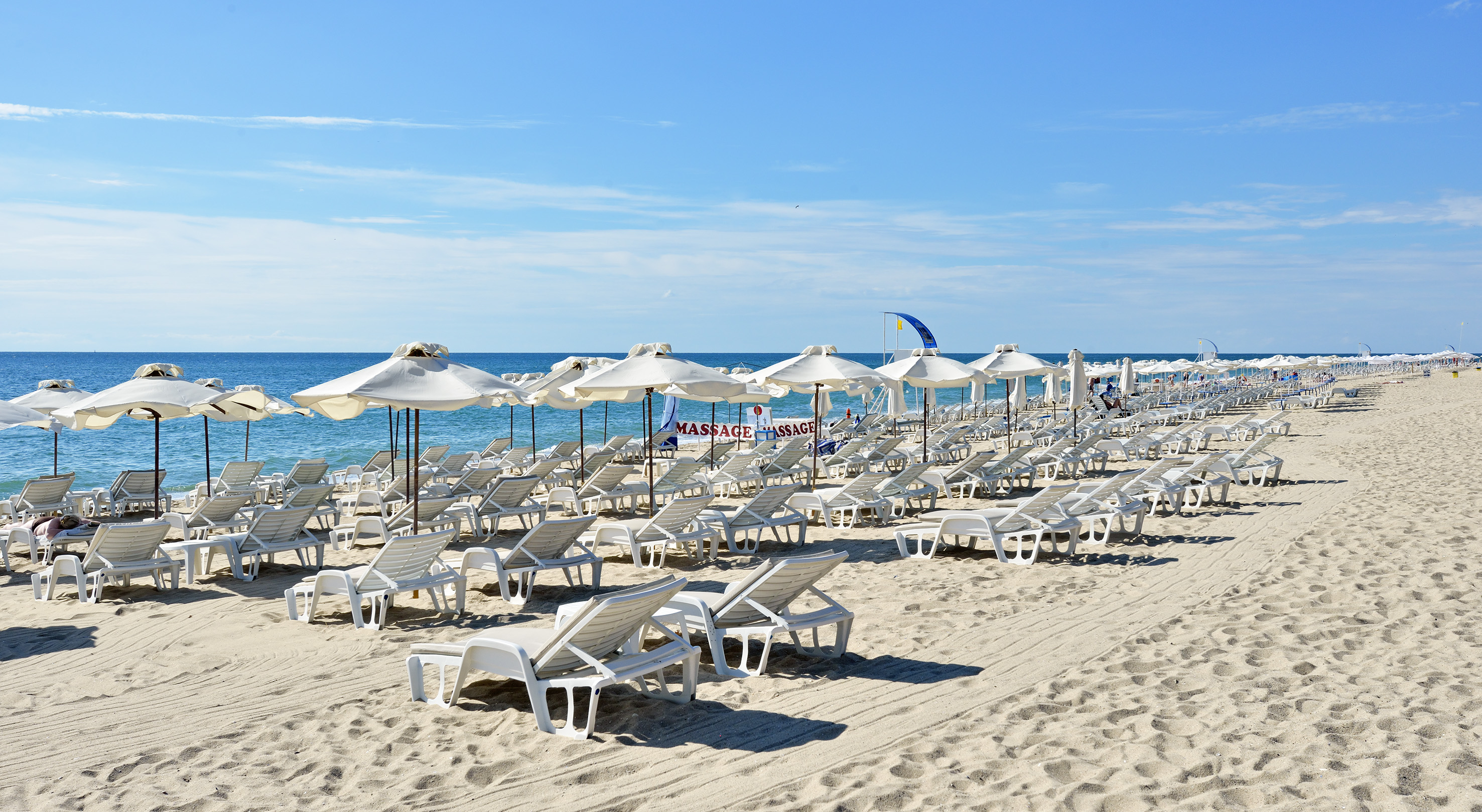 a beach with chairs and umbrellas