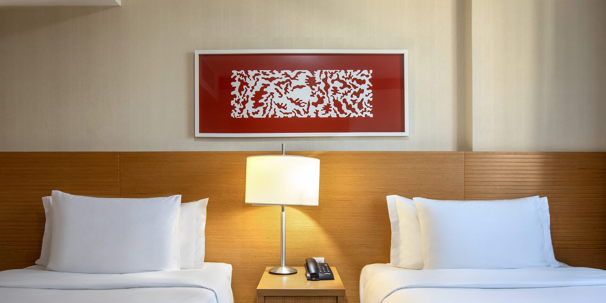 a room with two beds and a lamp