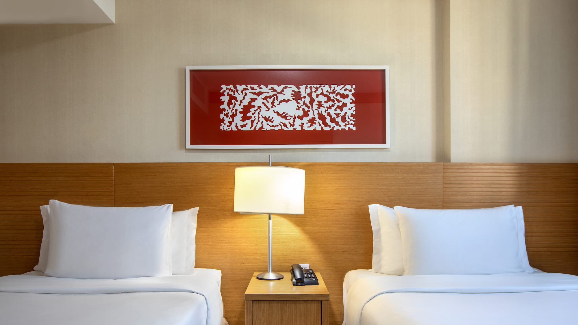 a room with two beds and a lamp