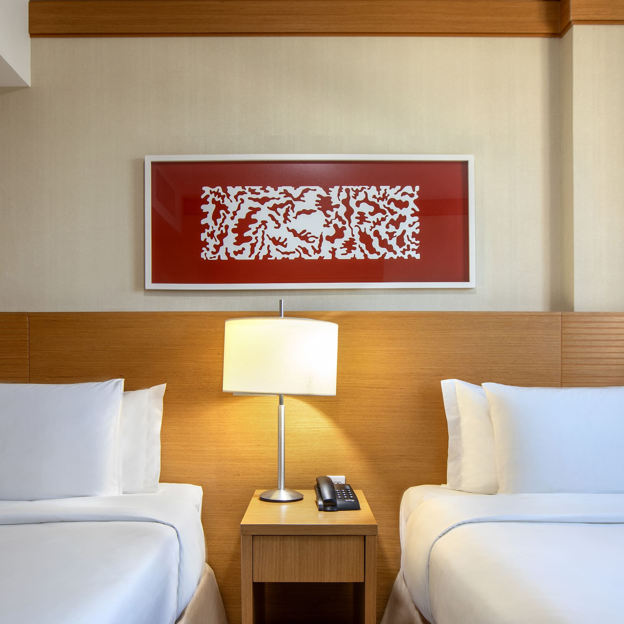 a room with two beds and a lamp