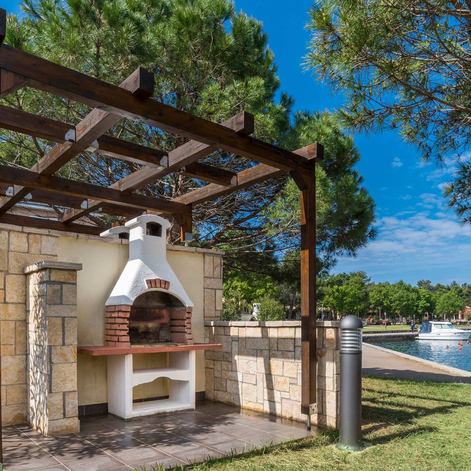 a outdoor fireplace with a wood pergola over it